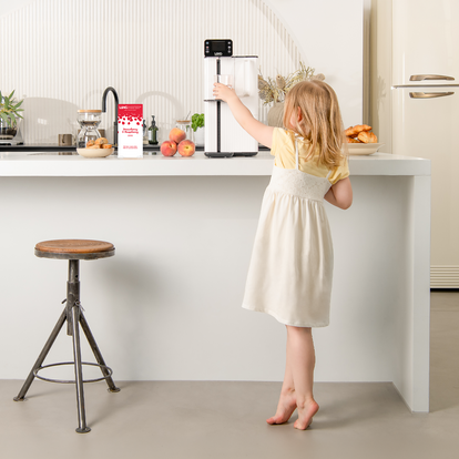 Child in a kitchen reaching the Lang water filtration machine