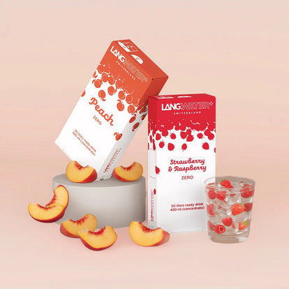 Two boxes of Langwater drinks with peach and strawberry raspberry flavors on a pink background.